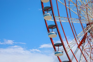 Beautiful large Ferris wheel against blue sky with clouds, closeup
