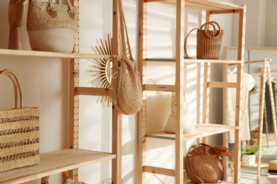 Photo of Stylish woman's bags on shelves in boutique