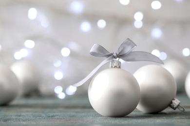 Beautiful Christmas balls on table against blurred festive lights. Space for text