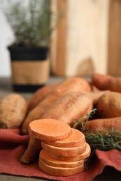 Napkin with thyme and sweet potatoes on table