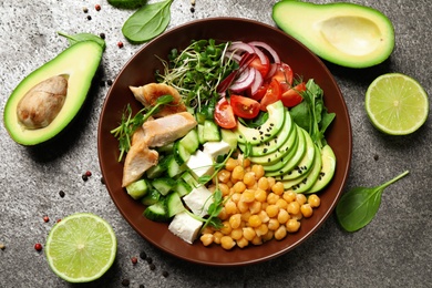 Delicious avocado salad with chickpea on grey table, flat lay