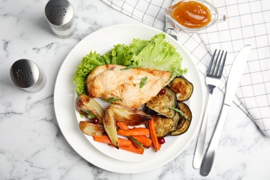 Photo of Delicious cooked chicken and vegetables served on white marble table, flat lay. Healthy meals from air fryer