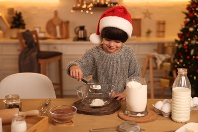 Cute little boy making Christmas cookies in kitchen