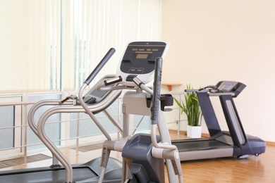 Elliptical trainers and treadmills in gym. Modern sport equipment