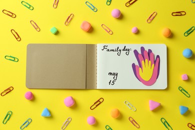 Happy Family Day. Flat lay composition with notebook on yellow background