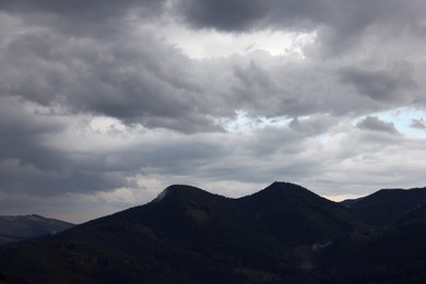View of sky with grey thunder clouds over mountains
