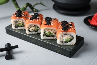 Delicious sushi rolls served on light grey table
