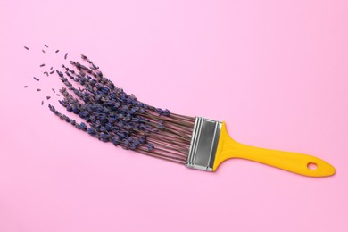 Creative flat lay composition with paint brush and lavender flowers on pink background