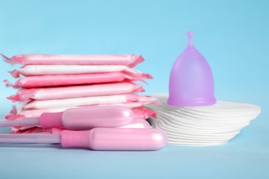Menstrual pads and other hygiene products on light blue background, closeup
