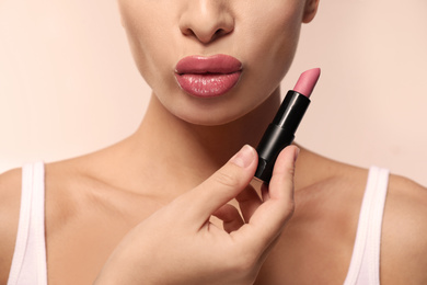 Woman with pink lipstick on light background, closeup