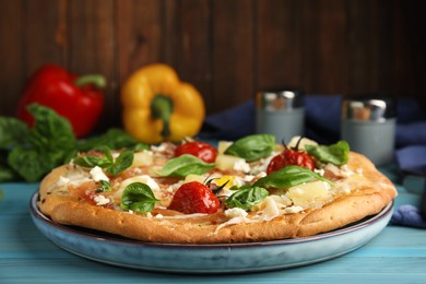 Delicious homemade pita pizza on light blue wooden table