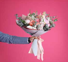 Man holding beautiful flower bouquet on pink background, closeup. Space for text