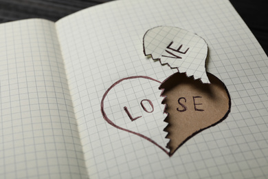 Broken heart with words LOVE and LOSE in notebook on table, closeup. Relationship problems concept