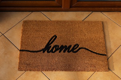 Photo of Doormat with word Home near entrance outdoors
