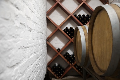 Wooden barrels on stand in wine cellar, closeup