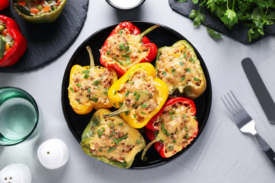 Tasty stuffed bell peppers served on light grey table, flat lay