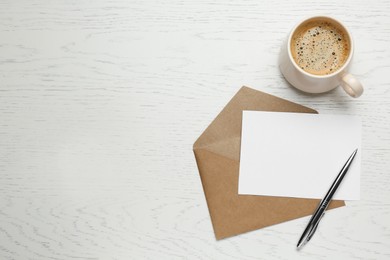 Photo of Envelope with blank paper card, cup of coffee and pen on white wooden table, flat lay. Space for text