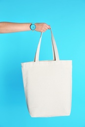 Woman holding eco bag on color background. Mock up for design