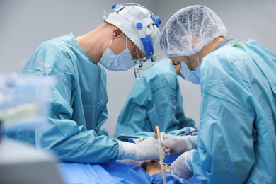 Photo of Professional doctors performing 
frontal sinus trephination in surgery room