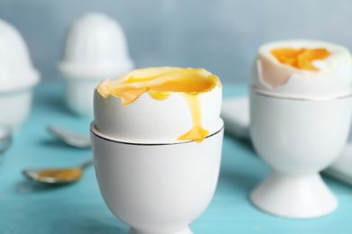 Soft boiled chicken egg served on light blue table, closeup