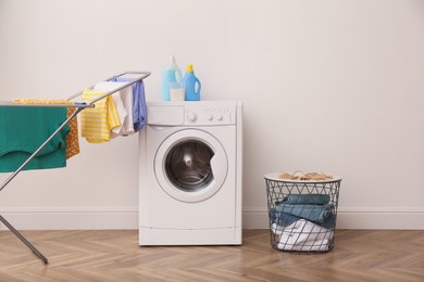 Laundry room interior with modern washing machine and drying rack
