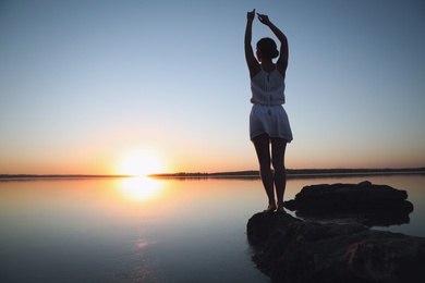 Woman near river on sunset. Healing concept