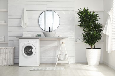 Stylish bathroom interior with modern washing machine