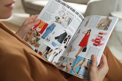 Woman reading fashion magazine at home, closeup