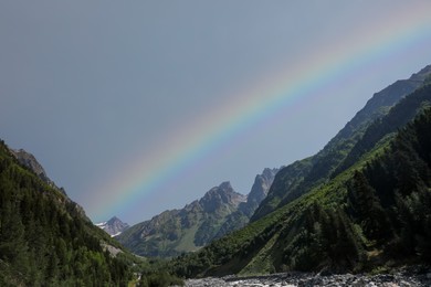Picturesque view of beautiful rainbow over mountains