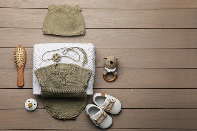 Flat lay composition with baby knitwear on wooden background, space for text. Cute photoshoot outfit