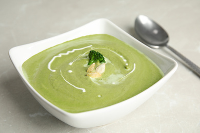 Delicious broccoli cream soup served on grey marble table