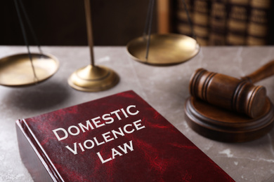 Domestic violence law and gavel on grey marble table, closeup