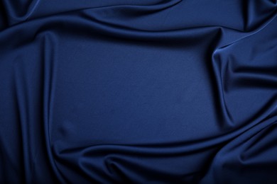 Crumpled dark blue silk fabric as background, top view. Space for text