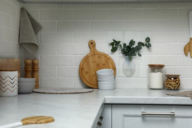 Silicone vase with eucalyptus branches on wall over countertop in kitchen