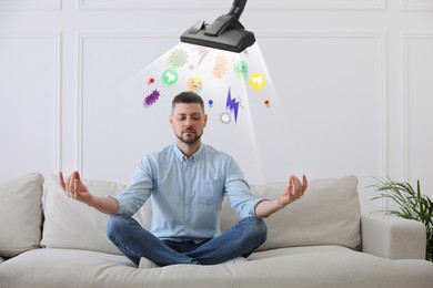 Image of Purification of mind. Vacuum cleaner extracting bad thoughts from meditating man on sofa indoors