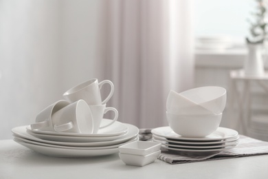 Photo of Set of clean dishware on white table indoors
