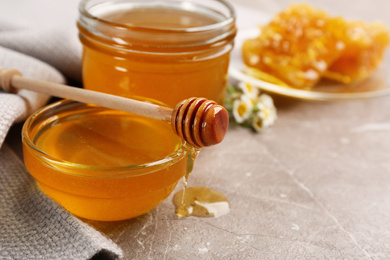 Tasty honey on brown marble table, closeup