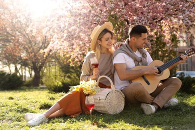 Lovely couple having picnic in park on sunny spring day