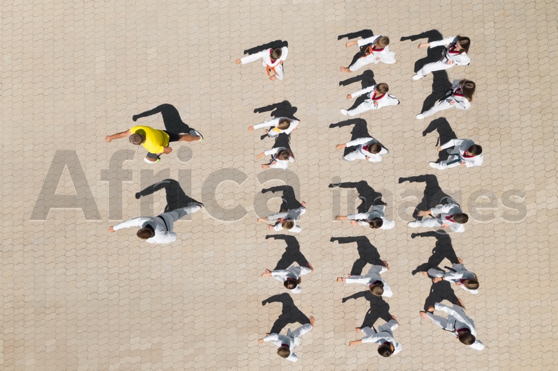 OCHAKIV, UKRAINE - JULY 09, 2020: Children practicing karate with coaches outdoors, aerial top view. Spending time in summer camp "Sportium"