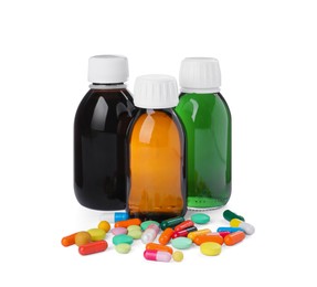 Photo of Bottles of syrups with pills on white background. Cough and cold medicine