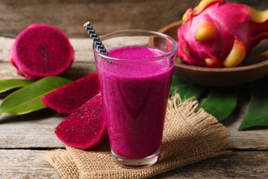 Glass of tasty pitahaya smoothie and fresh fruits on wooden table