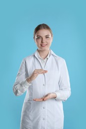 Dental assistant holding something on light blue background