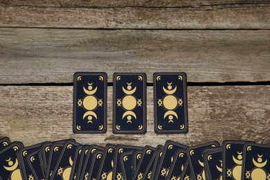 Tarot cards on wooden table, top view and space for text. Reverse side