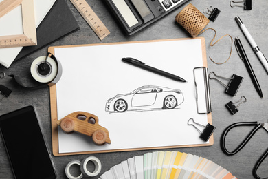 Flat lay composition with drawing of car on grey table. Designer's workplace