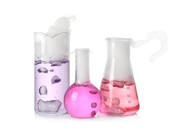 Photo of Laboratory glassware with colorful liquids and steam isolated on white. Chemical reaction