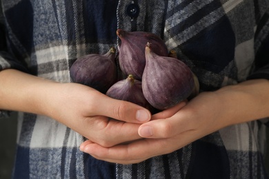 Woman holding tasty raw purple figs, closeup