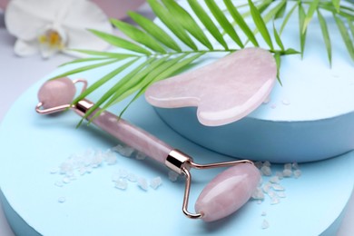 Photo of Beautiful composition with gua sha stone and face roller on color background