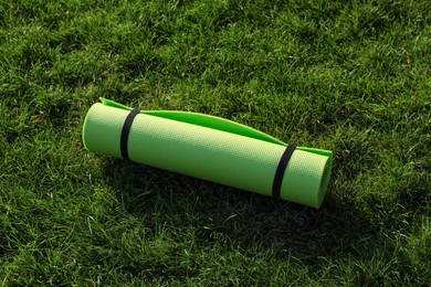 Bright exercise mat on fresh green grass outdoors