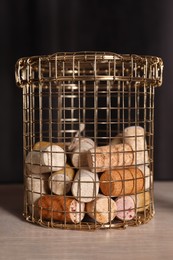 Metal basket with corks on rack against black background