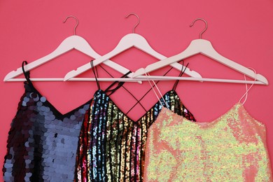 Collection of women's garments on pink background, flat lay. Clothes rent concept